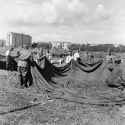 Sotilaita pystyttämässä telttaa kisaturisteja varten Lauttasaaren leirintäalueella, nykyisen Pajalahden puiston paikalla. Kisoihin saapuvan yleisön määrä arvioitiin niin suureksi, että majoitusapua pyydettiin Puolustusvoimiltakin.