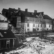 Puinen monikerroksinen asuintalo Pasilassa 1900-luvun alussa. Pasilan ratapiha-alueen ympärille nousi tiivistä työläisasutusta. Pasilan taajaväkinen yhdyskunta liitettiin osaksi Helsinkiä vuonna 1912.