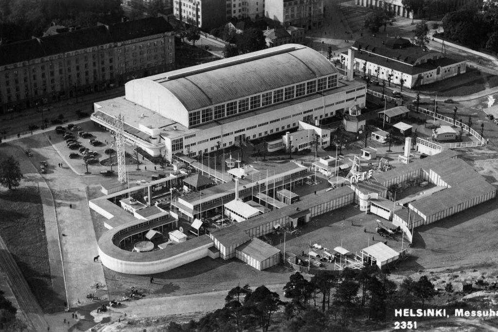 Suurmessut 1935 ulottui laajalle varsinaisesta Messuhallista. Ilmakuva on otettu kaakosta. Vasemmalla ylhäällä näkyy Mannerheimintien kivitaloja, oikealla ylhäällä Hippodromi. Etualalla näkyvät rakennelmat olivat tilapäisiä messupaviljonkeja. Kuvaaja: Helsingin kaupunginmuseo / Veljekset Karhumäki Oy