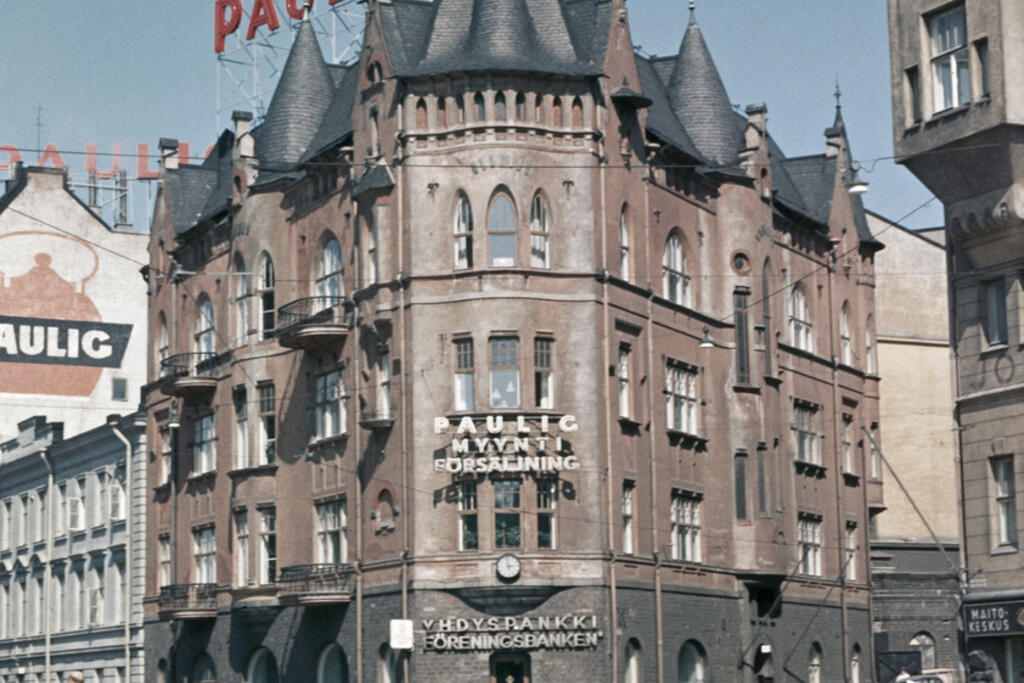 Förr doftade det kaffe på Skatudden, eftersom där fanns flera kafferosterier. I mitten av bilden står Tallbergska huset, den lägre byggnaden på dess vänstra sida är Wavulinska huset. Bilden är från år 1963. Foto: Helsingfors stadsmuseum / Constantin Grünberg
