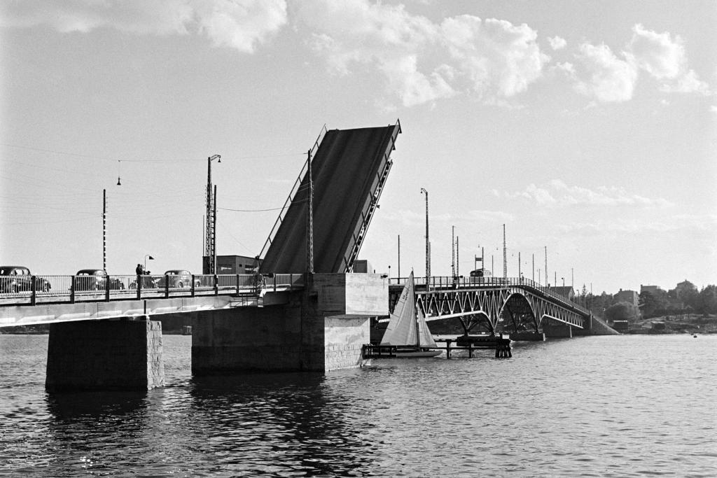 Lauttasaaren ensimmäinen silta Salmisaaresta päin kuvattuna vuonna 1953. Nostosilta on yläasennossa ja jono autoja odottaa päästäkseen sillan yli. Nostetun sillan alitse kulkee pieni purjevene.