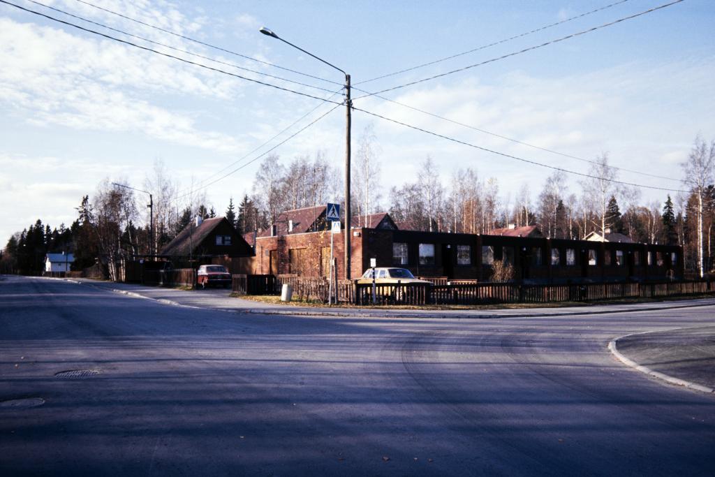 Paloheinäntie 43. Alkuperäinen kuvateksti 1980-luvulta pitää sitä esimerkkinä "pakiloitumisesta". 1980-luvulla ajateltiin, että täydennysrakentamisen myötä tiivistyneiden alueiden rakennukset eivät keskenään sopineet yhteen. Pakilaa pidettiin ilmiön ilmeisimpänä esimerkkinä.  Katsottiin, että myös kuvassa näkyvä vaihteleva rakennustyyli on esimerkki pakiloitumisesta. Kuvaaja: Helsingin kaupunginmuseo / Tuntematon kuvaaja