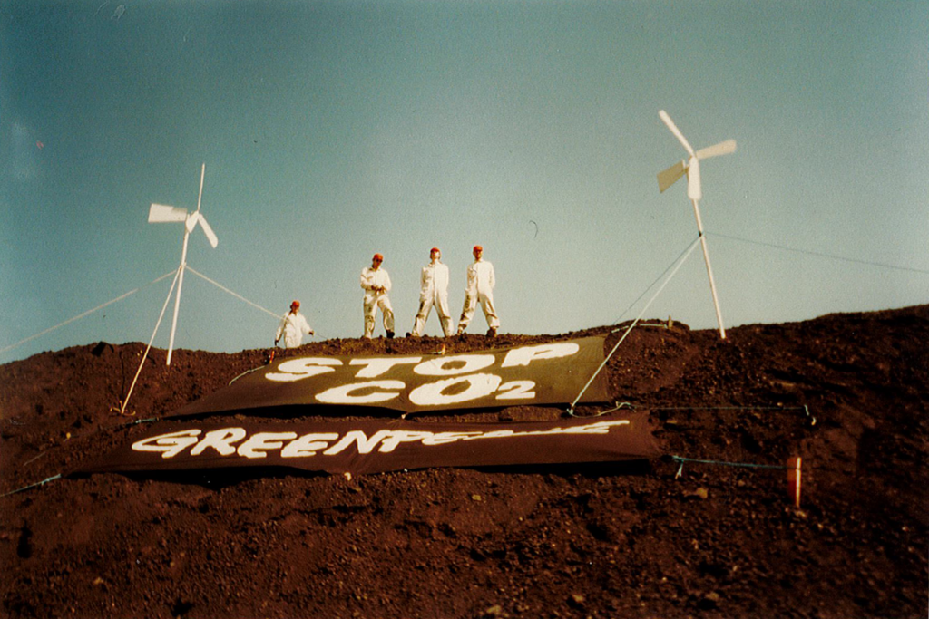 Ympäristöliike Greenpeacen mielenosoittajia Hanasaaren hiilikasan päällä vuonna 1997. Helsinkiläisten koteihin tulevalla sähköllä ja lämmöllä oli myös varjopuolensa: valtavat päästöt.  Ympäristöjärjestöt kampanjoivat pitkään Hanasaaren voimalan sulkemisen puolesta, sillä kivihiilellä toimiva laitos oli koko maan suurimpia hiilidioksidipäästöjen lähteitä. Kuvaaja: Greenpeace