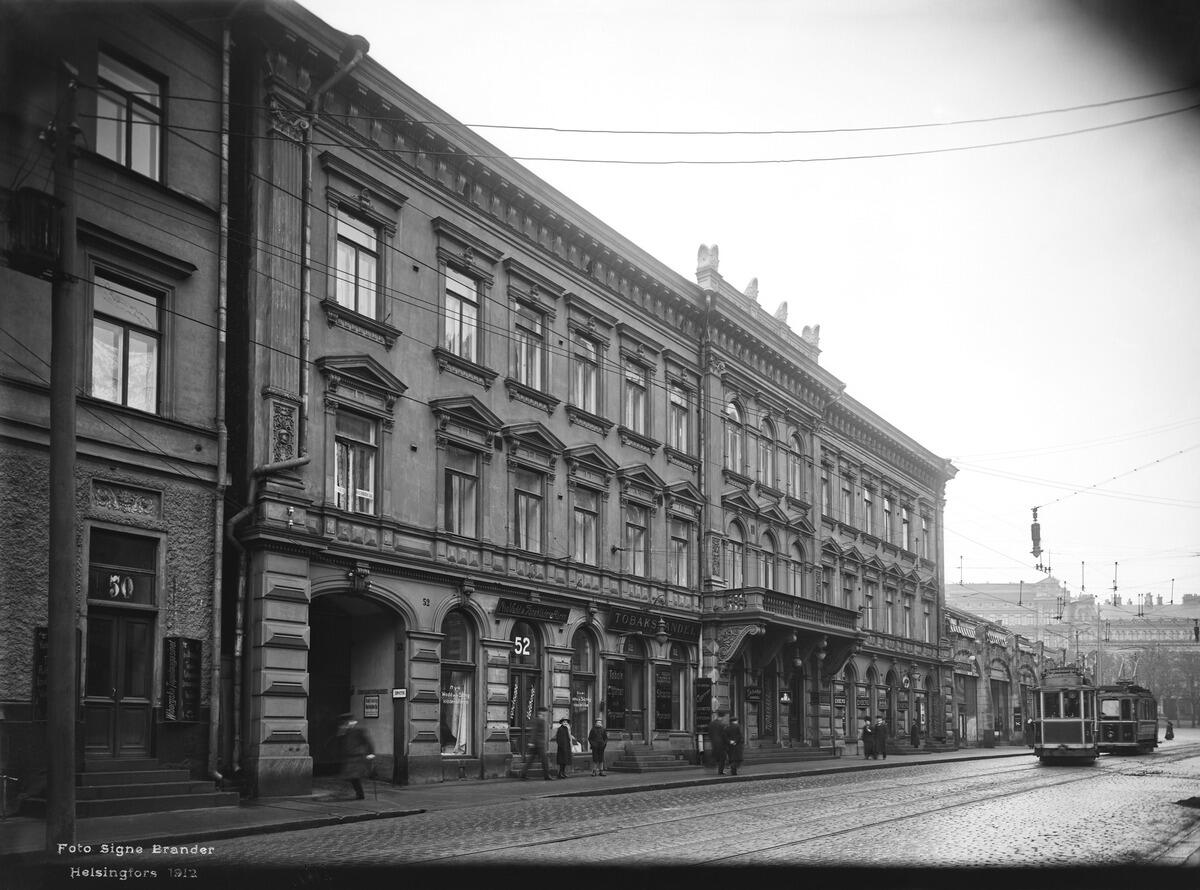 Kolmikerroksinen rakennus ja yksikerroksinen rakennus, joiden tilalle rakennettiin Keskuskatu ja Stockmannin tavaratalo.