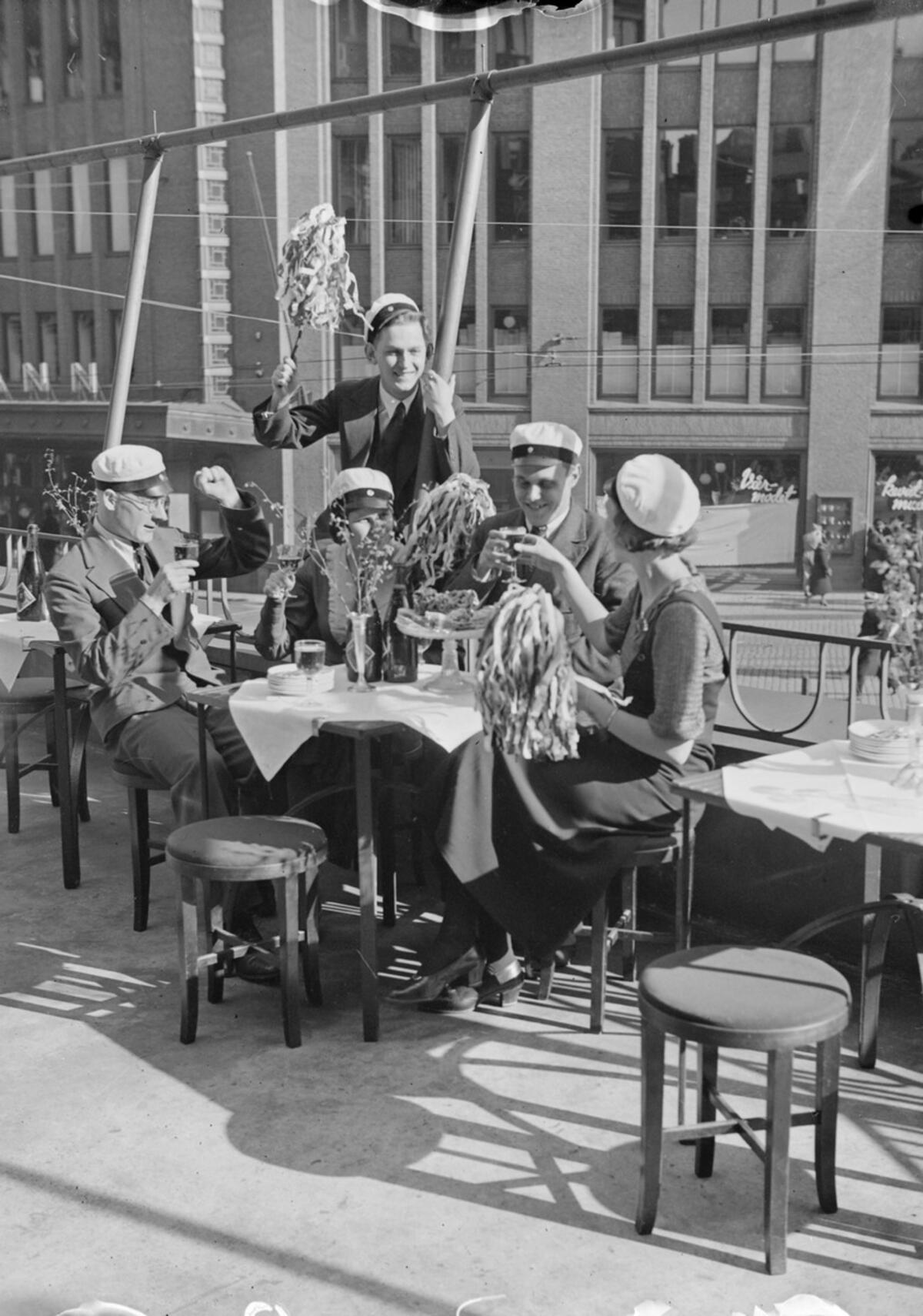 Ravintolat ja niiden terassit ovat olennainen osa urbaania vappua. Tässä ylioppilaat juhlivat Vanhan ylioppilastalon terassilla vappuna 1933. Kuvaaja: Museovirasto / Pietinen