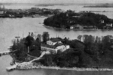 Edessä Suomalaisen Pursiseuran rakennus Nihtisaarella, pyöreällä Sompasaarella erottuu näkötorni saaren korkeimmalla kohdalla, saari oli osuusliike Elannon käytössä vuodesta 1921, siellä toimi Elannon työntekijöiden lasten kesäsiirtola. Taustalla on Sörnäisten satama-aluetta, oik. Kulosaaren silta.