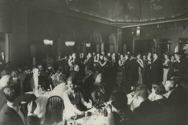 Kansallis-Osake-Pankin 40-vuotisjuhlat. Asiakkaita aterioimassa, taustalla ihmisiä tanssimassa.