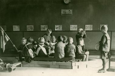 Ryhmä lapsia on rakentanut isoista palikoista "laivan" huoneen lattialle. Kymmenkunta lasta istuu "laivan" kyydissä. 