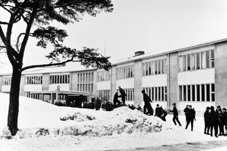 Oppilaat ovat välitunnilla Taivallahden kansakoulun (nykyään Taivallahden peruskoulu) lumisella pihalla, Eteläinen Hesperiankatu 38