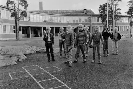 Meilahden ala-asteen oppilaita koulun pihalla pesäpallovarusteiden kanssa