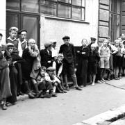 Pojat odottavat myytäviä sähkösanomia Helsingin Sanomien painon edessä Ludviginkadulla vuonna 1938. Kuva: Päivälehden arkisto