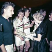 Miss Universe Armi Kuusela handing out olive branches to the Hungarian team who have just won gold in football. Photograph: Olympia-kuva oy / Helsinki City Museum   