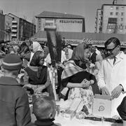 Pääsiäistapahtuma Herttoniemen torilla 1962. Myyjien työasu oli valkoinen takki, pääsiäisnoitien ilmeisesti huivi.