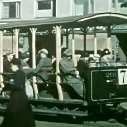 Avomallisessa raitiovaunussa istuu ihmisiä. Vaunun kyljessä on numero 7.