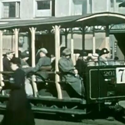 Avomallisessa raitiovaunussa istuu ihmisiä. Vaunun kyljessä on numero 7.