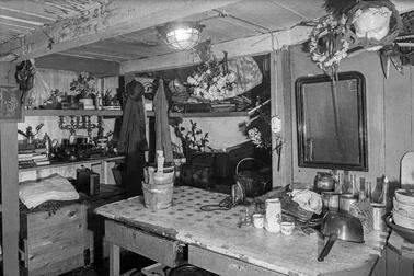 Ett lågt källaraktigt utrymme med många attiraljer på vägghyllor och bord.