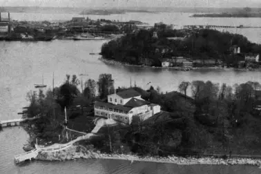 Edessä Suomalaisen Pursiseuran rakennus Nihtisaarella, pyöreällä Sompasaarella erottuu näkötorni saaren korkeimmalla kohdalla, saari oli osuusliike Elannon käytössä vuodesta 1921, siellä toimi Elannon työntekijöiden lasten kesäsiirtola. Taustalla on Sörnäisten satama-aluetta, oik. Kulosaaren silta.