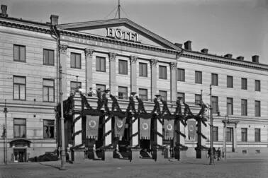 A photograph of the current Helsinki City Hall with the text “Hotel Societetshuset” on its wall.