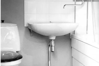 Till vänster en wc-bytta, i mitten en lavoar och till höger ett badkar samt en gemensam vattenkran för dessa. 
