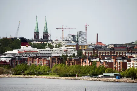 Katajanokka Kruunuvuorenselän yli Kruunuvuorenrannasta nähtynä. Asuinrakennuksia Katajanokan kärjessä. Asuinrakennusten takana Viking Linen risteilyalus. Vasemmalla takana Johanneksen kirkko Ullanlinnassa. Keskellä takana rakenteilla oleva Hotel Clarion Helsinki Jätkäsaaressa.