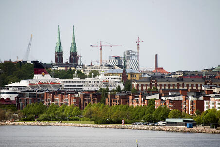 Katajanokka Kruunuvuorenselän yli Kruunuvuorenrannasta nähtynä. Asuinrakennuksia Katajanokan kärjessä. Asuinrakennusten takana Viking Linen risteilyalus. Vasemmalla takana Johanneksen kirkko Ullanlinnassa. Keskellä takana rakenteilla oleva Hotel Clarion Helsinki Jätkäsaaressa.