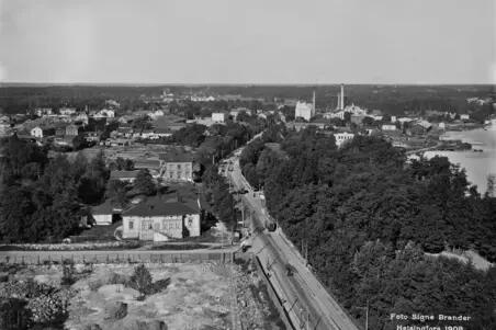 Panoraama Kansallismuseon tornista pohjoiseen. Kuvassa näkyy matalia taloja, puita, kalliota ja maantie.