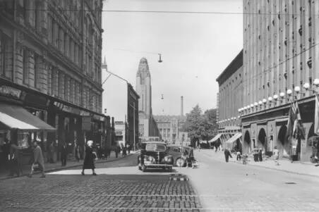 Keskuskatu 5, 7, 4, 8. Kadulla näkyy autoja ja jalkakäytävillä ihmisiä.