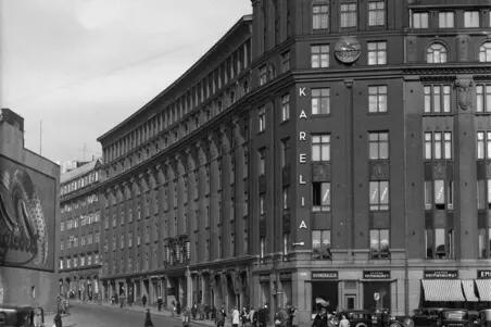 Mikonlinna Kaisaniemenkatu 1 - Mikonkatu 13. Etualalla autoja ja jalankulkijoita.