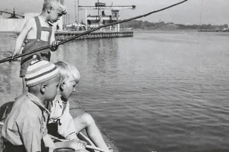 Tre pojkar metar med självgjorda meten. I bakgrunden syns Sörnäs hamn.