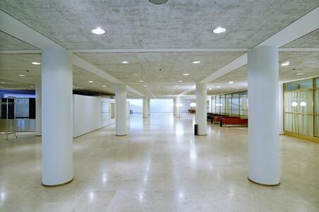 Stadshusets entréhall. I den öppna lokalen finns runda, vita pelare. Naturligt ljus kommer in i rummet från entréhallens gavel. Ytorna är ljusa.
