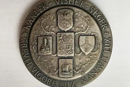 Baksidan av medaljen pryds av fem sköldar placerade i formen av ett kors. Överst är fågeln fenix.