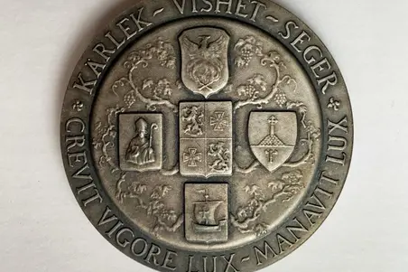 Hopeasta valettu pyöreä mitali. Yhdellä puolella messinkiä kiertää motto, toisella puolella on kaksi vuosilukua roomalaisin numeraalein ja vapaamuurariloosin nimi. Toisella puolen mitalia on kuva kahdesta kilvestä, joissa vasemman puoleisessa kulmaviivain ja harppi. Toinen kilpi on jaettu kahteen päällekkäiseen kenttään, joista ylemmässä on kulmaviivain ja harppi, alemmassa kolme kranaattia. Kilpien yllä kruunu. Kääntöpuolella on ristin muotoon asetetut viisi kilpeä, joista ylimmässä feeniks, keskellä nelik