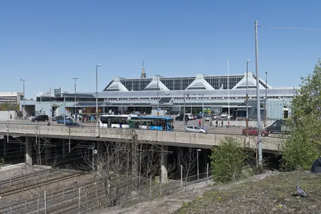 Böles station som blev färdig år 1990 fotograferad från Bangårdsvägen. Byggnaden är i blågråa toner och står upphöjd från rälsarna på pelare. Den har trekantiga takkonstruktioner. 