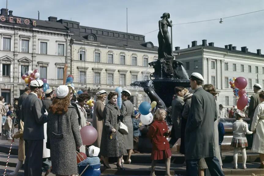 Vuxna och barn har samlats kring Havis Amanda. En del har en ballong i handen.