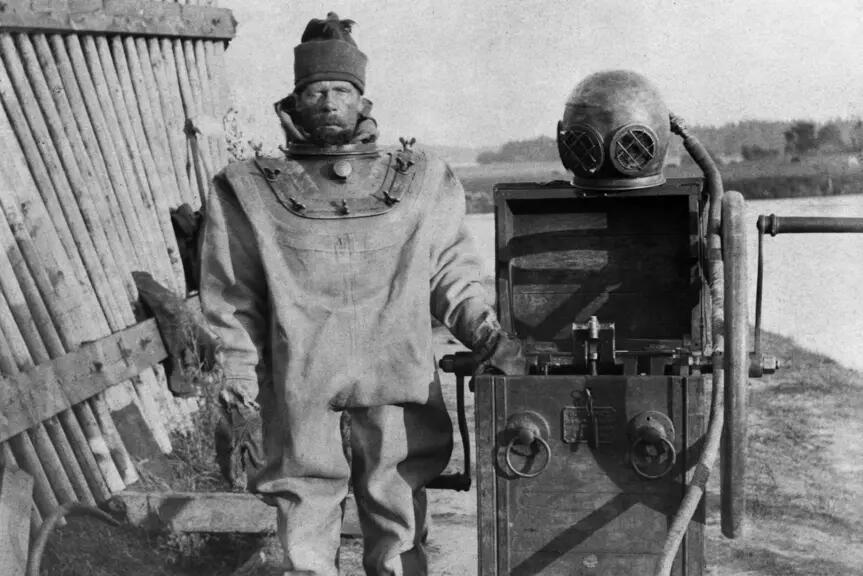 Man in an old fashioned diver's suit, diver's helmet on the right hand side