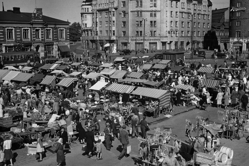 Näkymä Hakaniemen torille lintuperspektiivistä vuonna 1940. Tori on tupaten täynnä pieniä myyntikojuja ja ihmisiä.