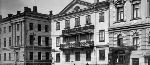 Pohjoisesplanadi 9, Kleinehs hotel, viereisessä talossa Pohjoisesplanadi 7 katutasossa venäläinen teekauppa sekä A.A. Berglundin räätälinliike (nyk. Ruotsin suurlähetystön talo).
