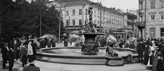 Havis Amanda -suihkukaivo Kauppatorilla paljastustilaisuuden jälkeen. Taustalla Pohjoinen Esplanaadikatu (Pohjoisesplanadi) 19 - Unioninkatu 28.