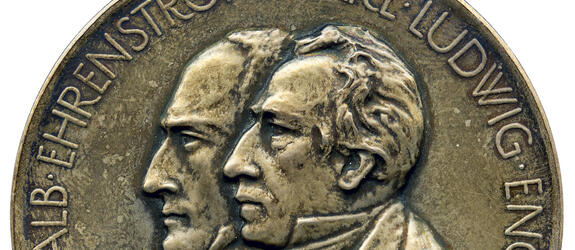 Medaljen har präglats med sidoprofilen av två män. Carl Ludvig Engels profil är i mitten av medaljen och Johan Albrecht Ehrenströms profil är lite till vänster. Båda personers namn går runt medaljens kanter.