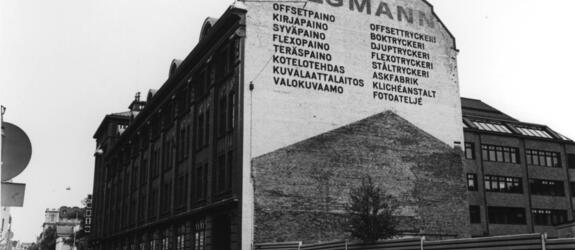 Tilgmanns tryckeri köpte 1872 den tomt som låg i hörnet av Annegatan och Lönnrotsgatan och byggde stegvis ett massivt hus där. Boktryckeriet flyttade sin verksamhet till Esbo i början av 1970-talet.