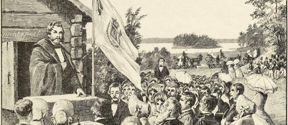 Piirroskuvassa on runsaasti juhlaväkeä. Keskellä liehuu lippu ja naisilla on päivänvarjot.