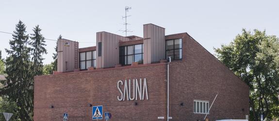 Tiiliverhoiltu rakennus, jossa suurin suuraakkosin teksti Sauna.