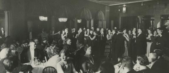 Kansallis-Osake-Pankin 40-vuotisjuhlat. Asiakkaita aterioimassa, taustalla ihmisiä tanssimassa.