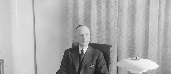 Eero Rydman istumassa työpöytänsä ääressä.