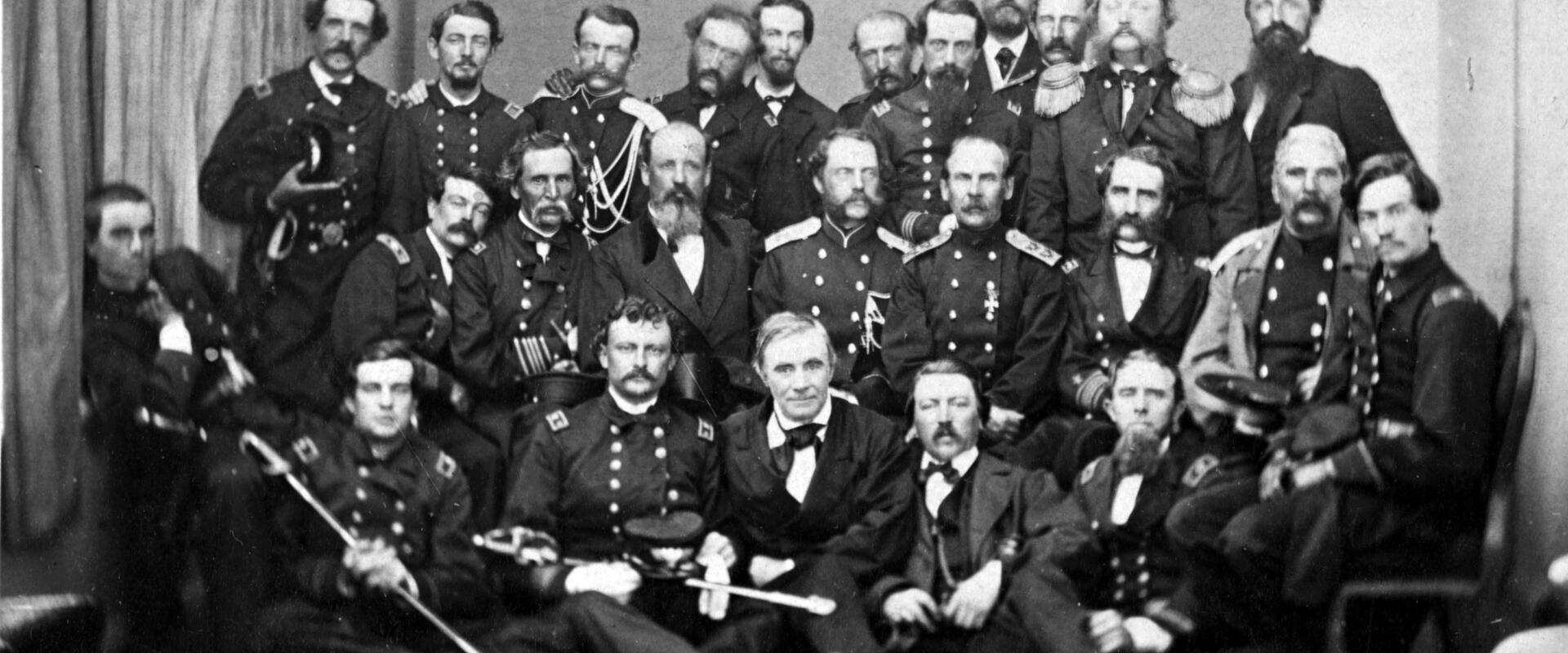 Noin 25 univormupukuista miestä kokoontuneena ryhmäkuvaan.
