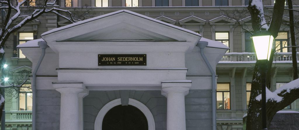 Kuva uusklassisesti koristeellisesta pienestä kivisestä rakennuksesta. Oven yläpuolella lukee Johan Sederholm.