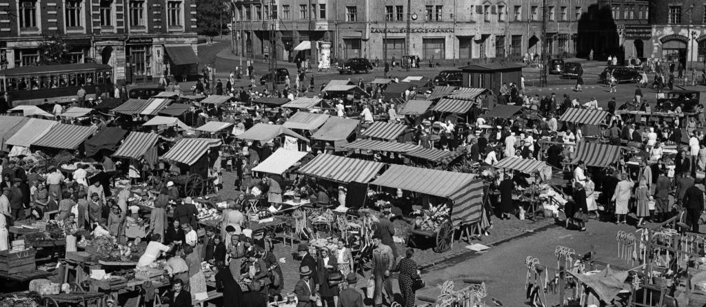 Näkymä Hakaniemen torille lintuperspektiivistä vuonna 1940. Tori on tupaten täynnä pieniä myyntikojuja ja ihmisiä.