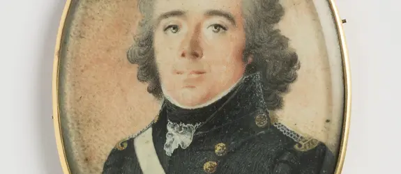 Bystbild av en man med blicken framåt. Gråa ögon, pudrat halvlångt lockigt hår. Svenska flottans uniform: mörkblå jacka och väst med gyllene knappar. Epåletter i silver och guld, ett vitt band löper över höger axel. Vitt halskrås, svart halsduk. Vitt bandage på vänstra armen. Rödskimrande grå bakgrund. På baksidan ett svart K på förgylld botten. Ovanpå miniatyren ett glas. Tunn guldram med liten ögla. Mästarstämpel på ramen: WINBERG.