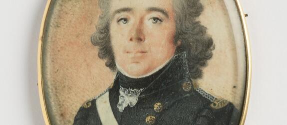 Bystbild av en man med blicken framåt. Gråa ögon, pudrat halvlångt lockigt hår. Svenska flottans uniform: mörkblå jacka och väst med gyllene knappar. Epåletter i silver och guld, ett vitt band löper över höger axel. Vitt halskrås, svart halsduk. Vitt bandage på vänstra armen. Rödskimrande grå bakgrund. På baksidan ett svart K på förgylld botten. Ovanpå miniatyren ett glas. Tunn guldram med liten ögla. Mästarstämpel på ramen: WINBERG.