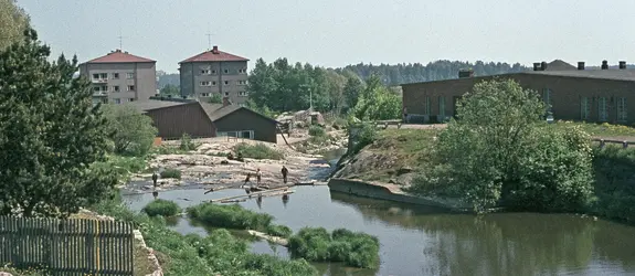 Barn är och leker vid Gammelstadsforsen. Till höger är Kungsgårdsholmen. I bakgrunden höghusen på Katarina av Sachsens gata 11 – Borgnässtigen 2.